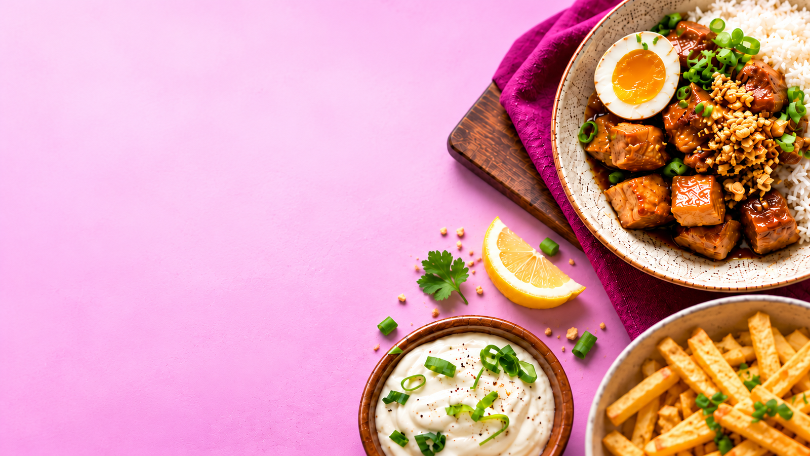 Chicken and rice with egg, golden fries, and creamy dip on a pink table